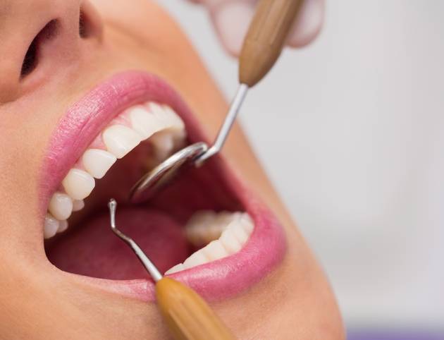 Close up of dentist examining female patient teeth